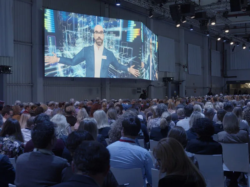 Virtual presenter on a large screen in front of the audience at a Janssen Pharma event